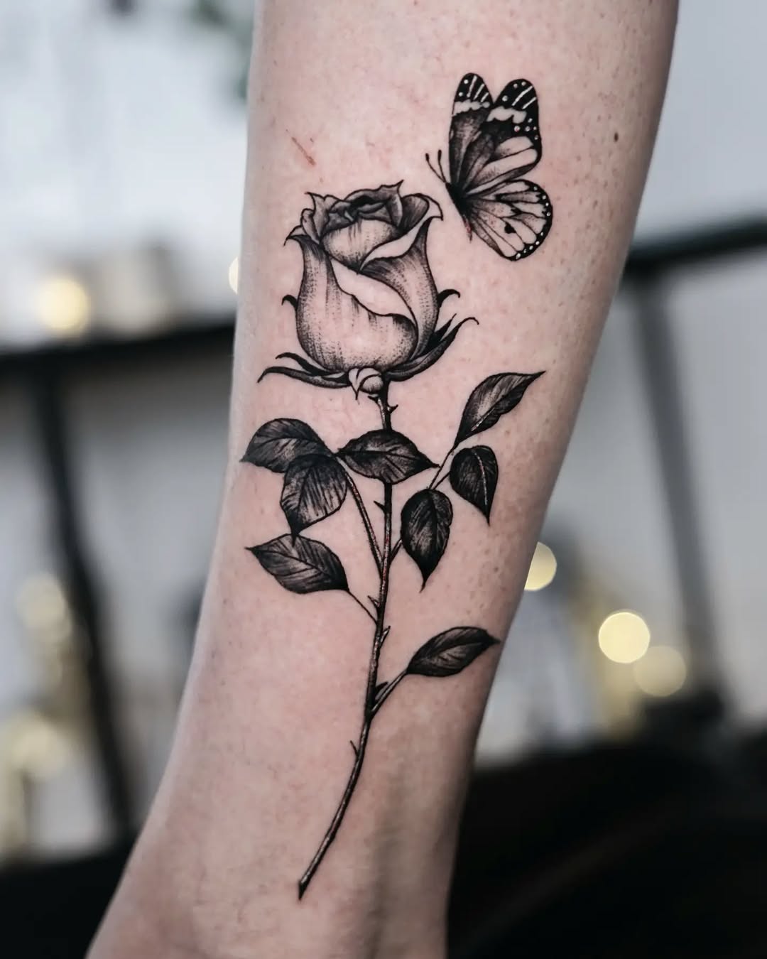 Elegant black and gray rose with butterfly tattoo