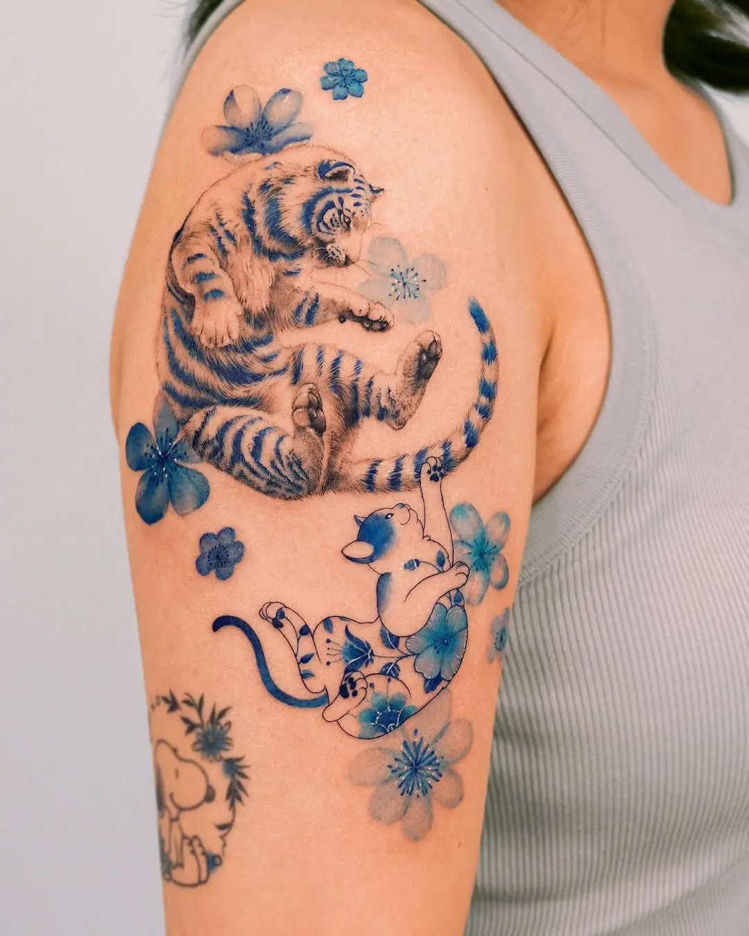 Playful tiger and cat tattoo with floral elements