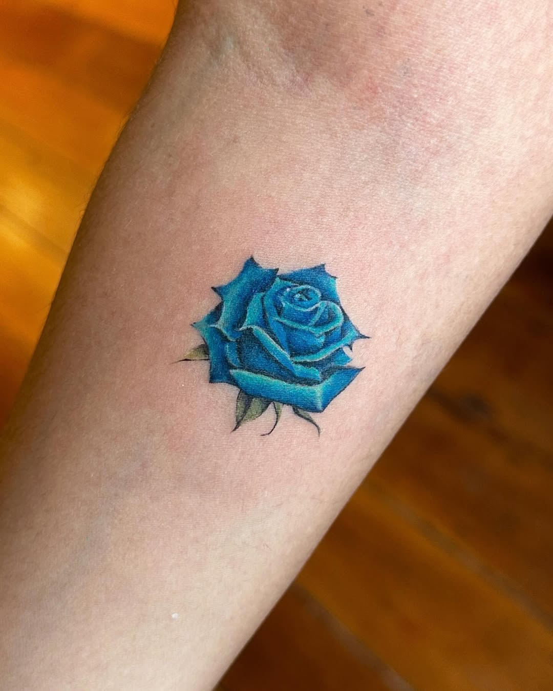 Vibrant blue rose tattoo showcasing intricate design