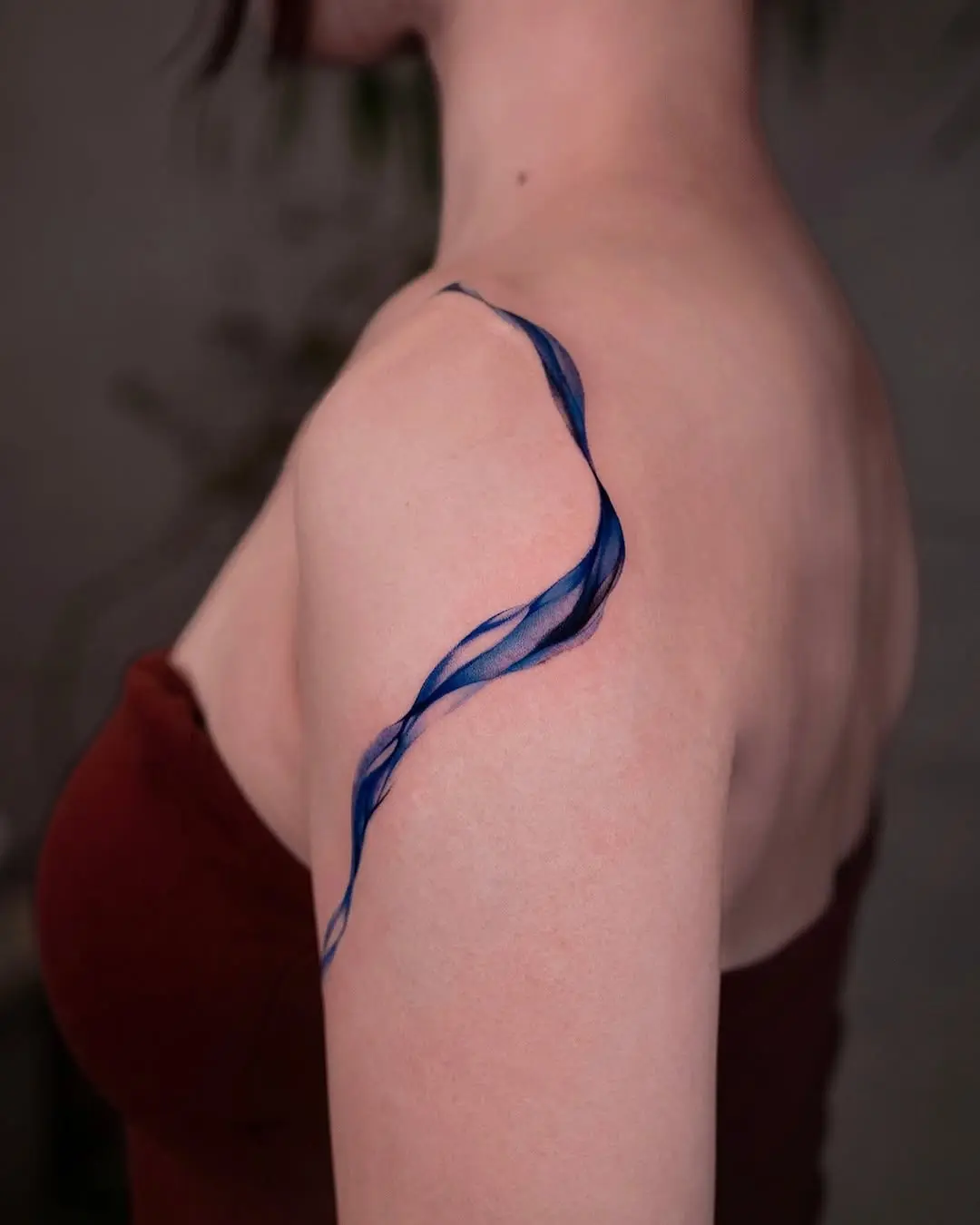 Elegant blue wave tattoo adorning the shoulder