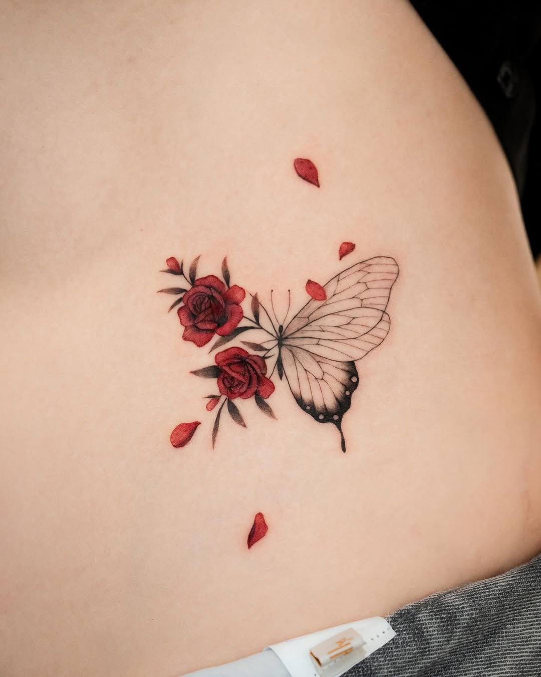 Delicate tattoo of a butterfly and roses