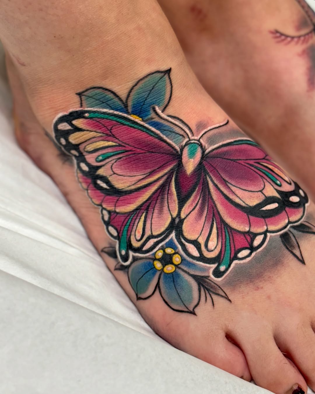 Colorful butterfly tattoo on foot