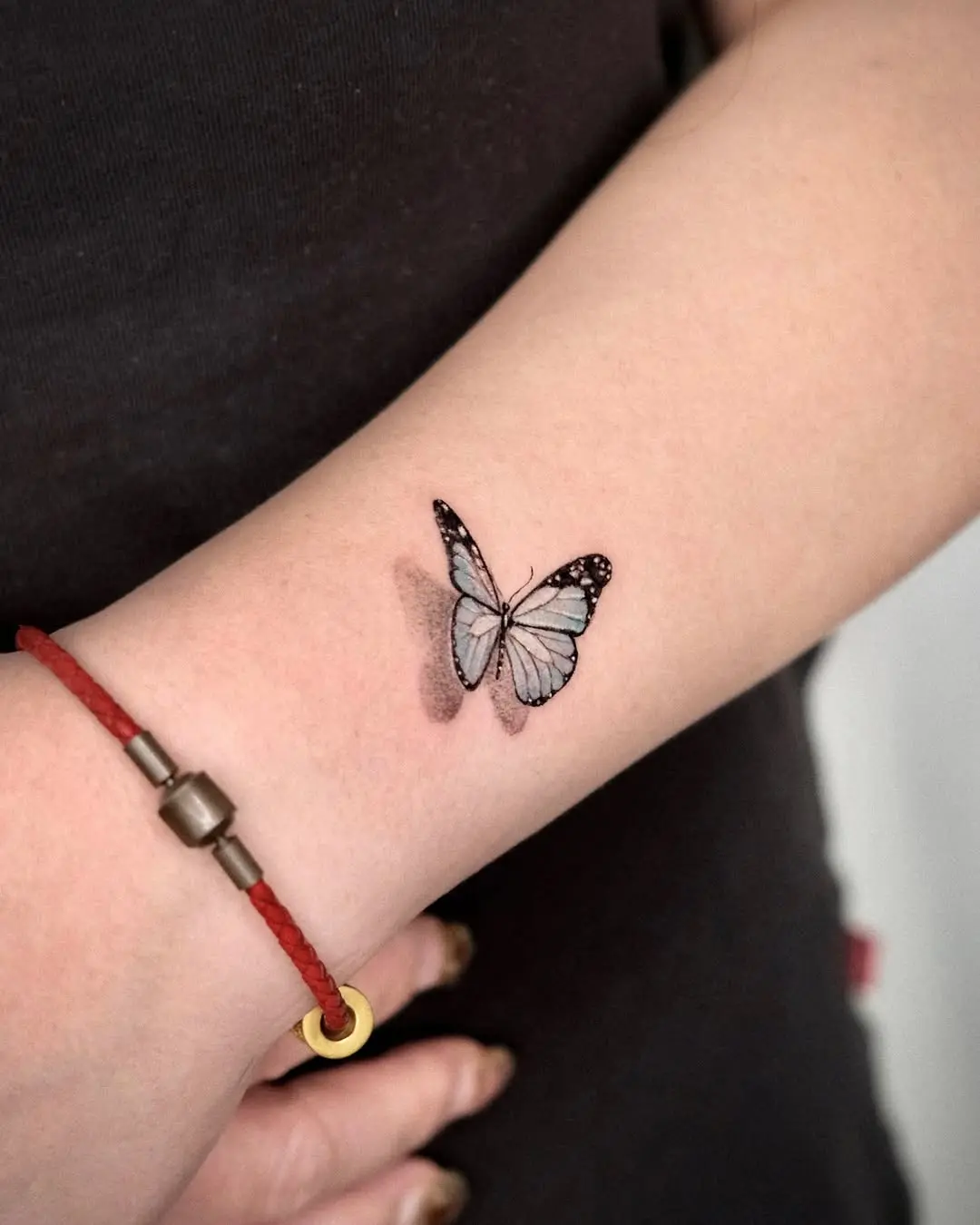Delicate butterfly tattoo with soft blue hues