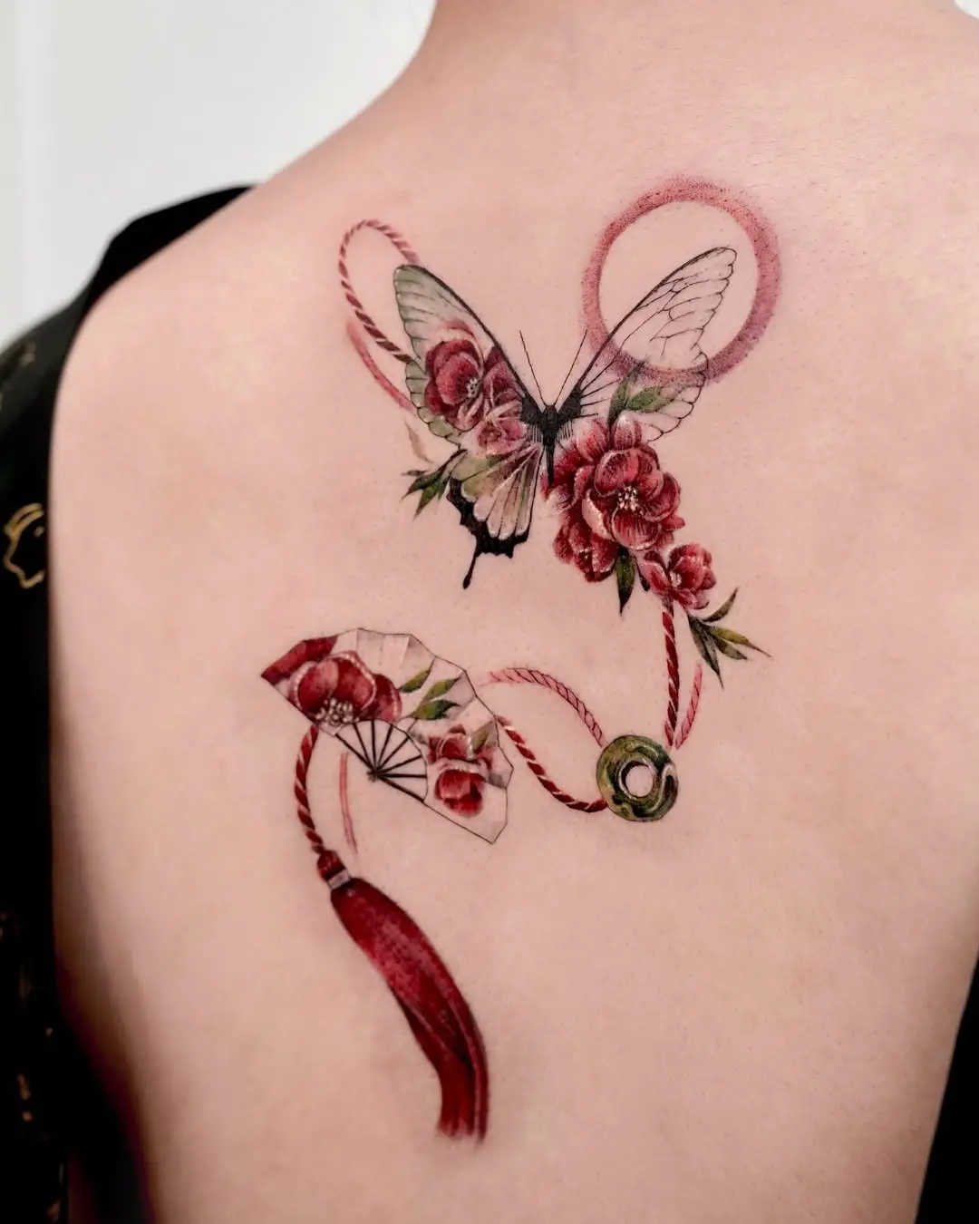 Elegant butterfly tattoo intertwined with flowers