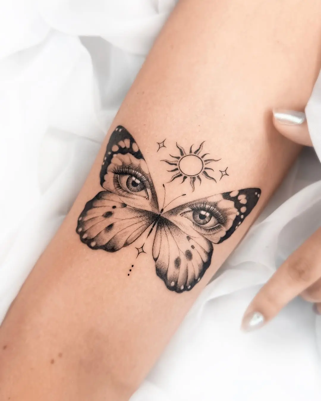 Stunning butterfly tattoo with eyes and sun