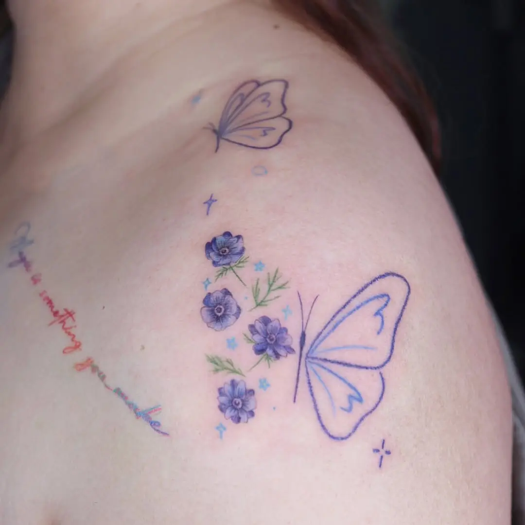 Delicate butterfly tattoo with floral elements.