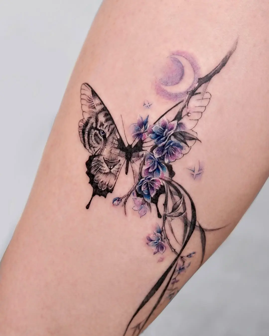 Elegant butterfly tattoo with floral accents
