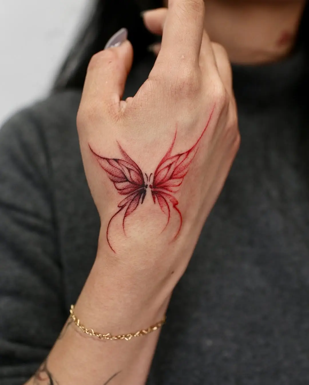 Stunning red butterfly tattoo on the hand