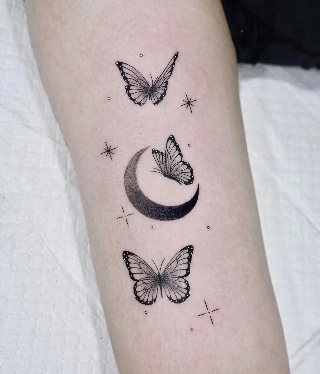 Elegant minimalistic butterfly and moon tattoo design