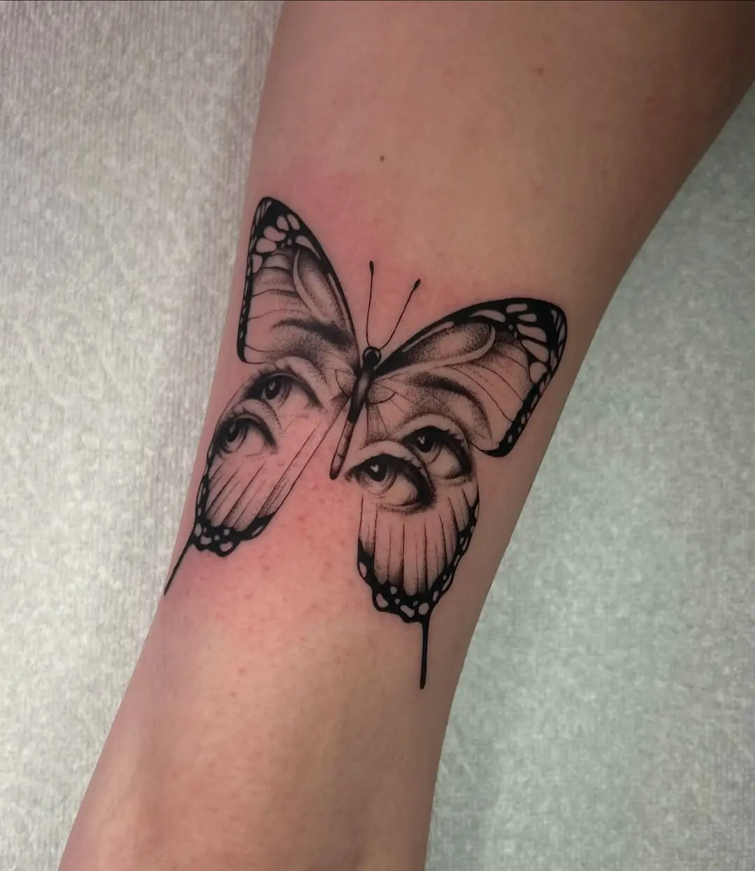 Intricate butterfly tattoo with hidden eyes detail