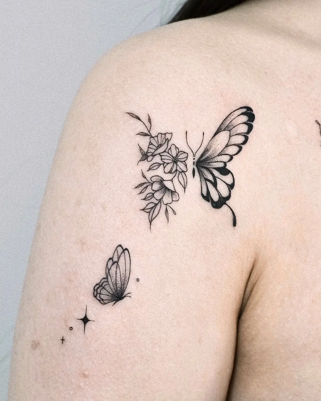 Elegant butterfly tattoo with floral accents