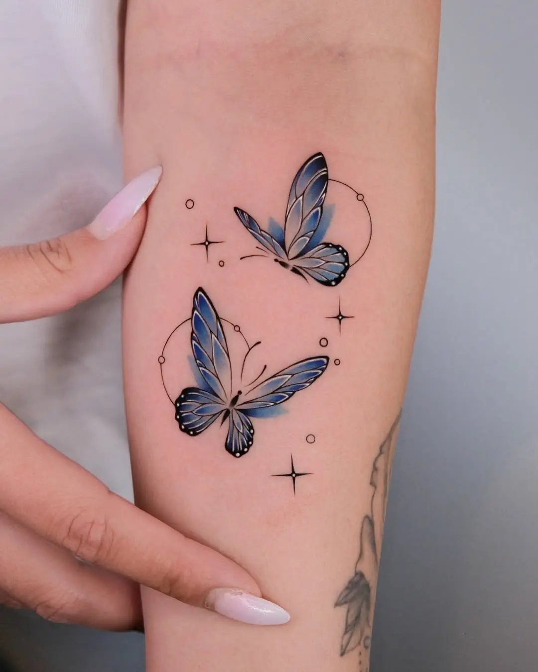 Elegant blue butterfly tattoos with cosmic accents
