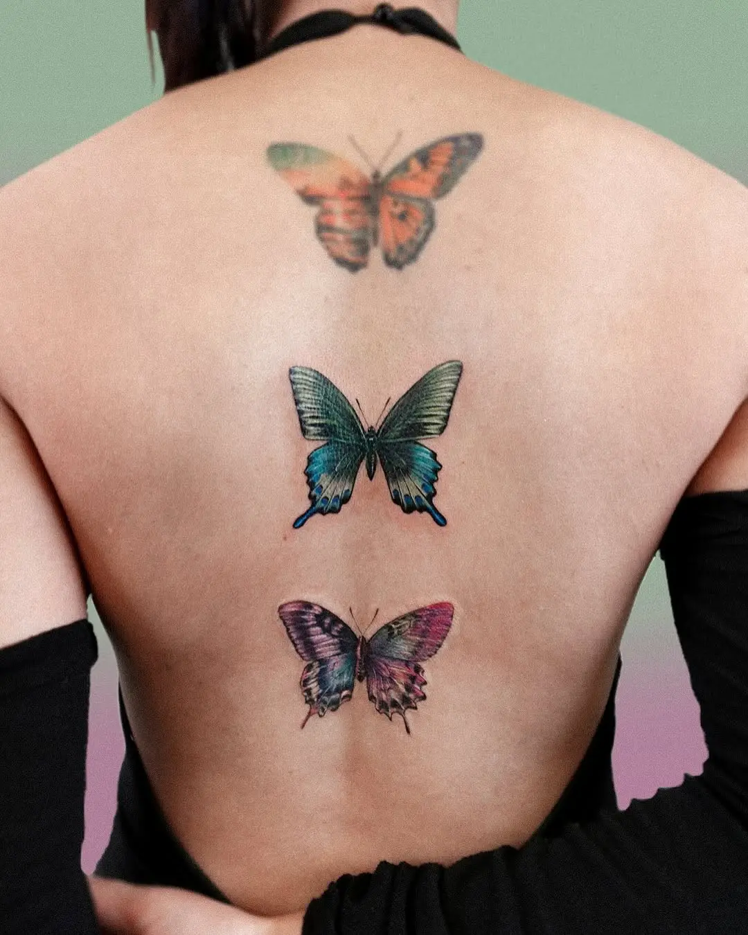 Colorful butterfly tattoos on bare skin