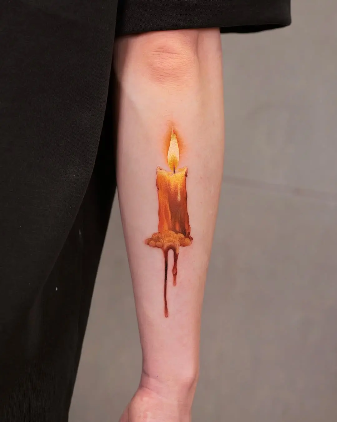 Realistic candle tattoo radiating warmth and glow