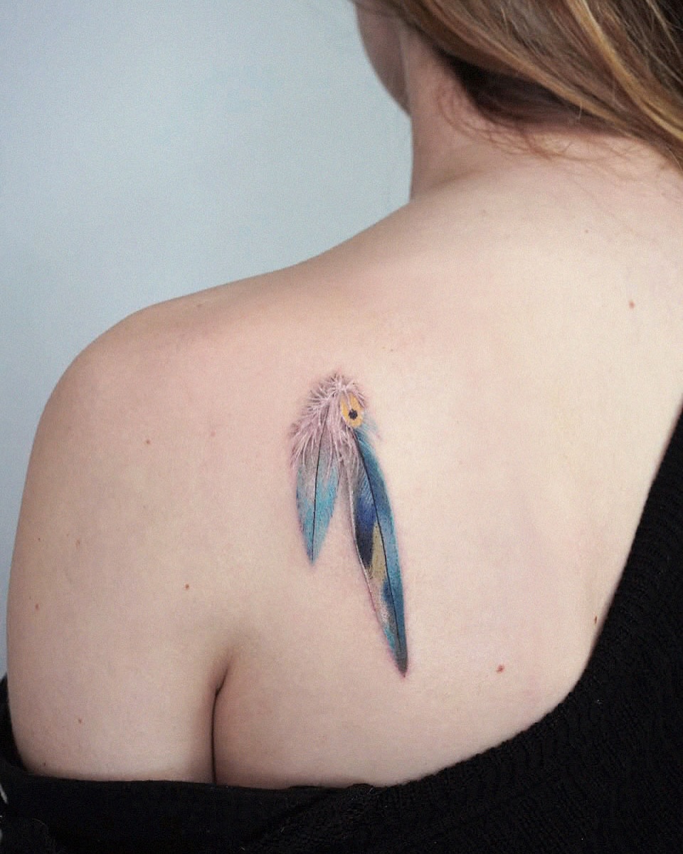 Elegantly vibrant feather tattoo on the shoulder.