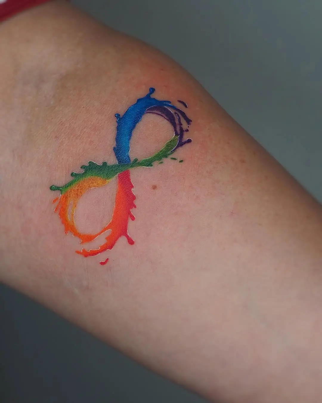 Vibrant infinity tattoo with splashes of color