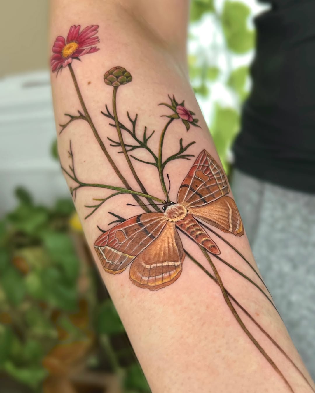 Elegant moth tattoo with vibrant floral accents