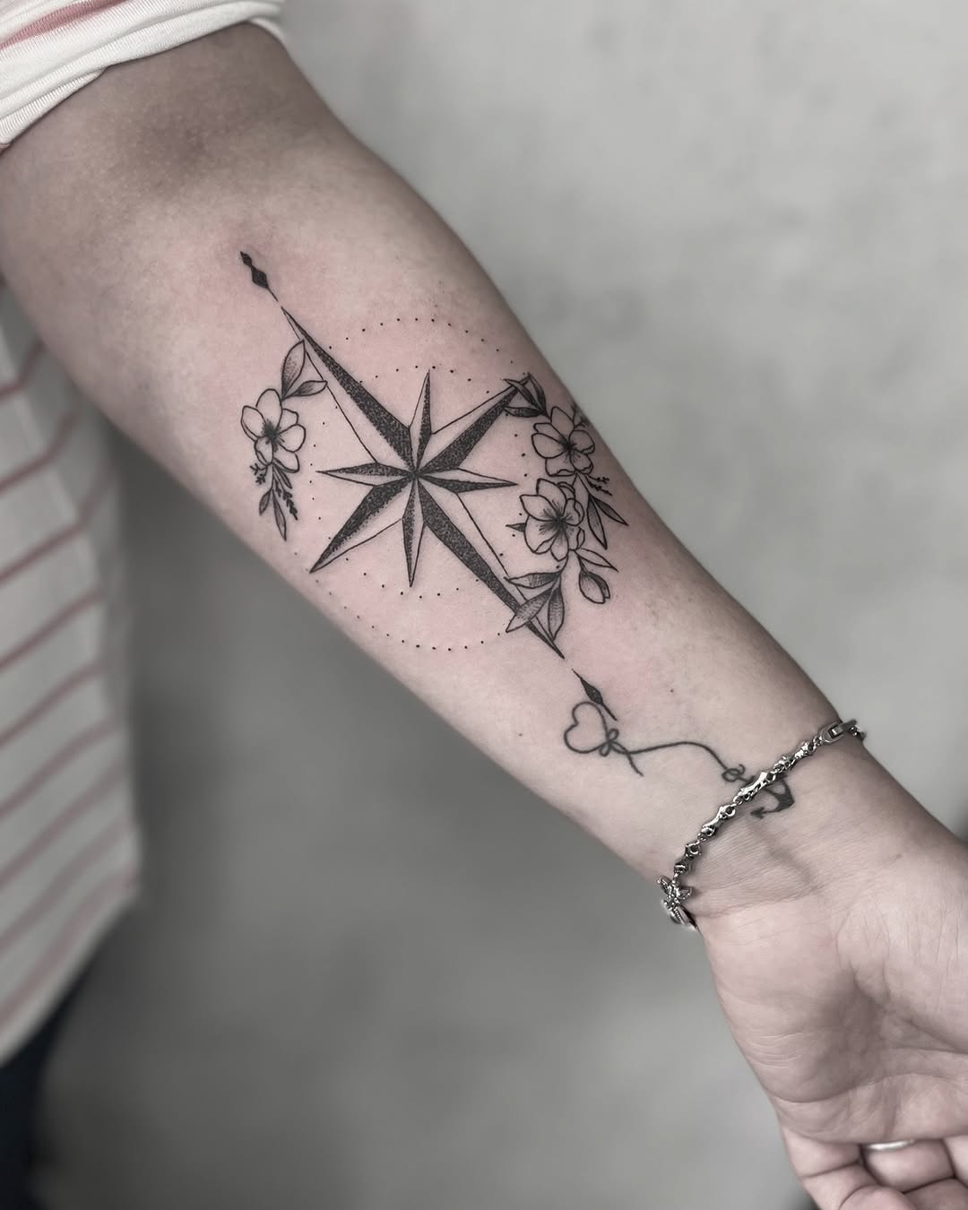 Intricate compass tattoo with floral accents.