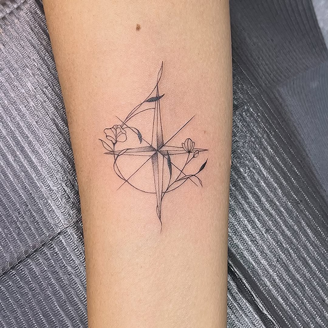 Elegant compass tattoo entwined with floral details