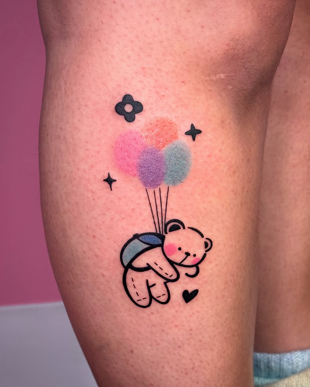 Adorable bear tattoo with playful balloon theme