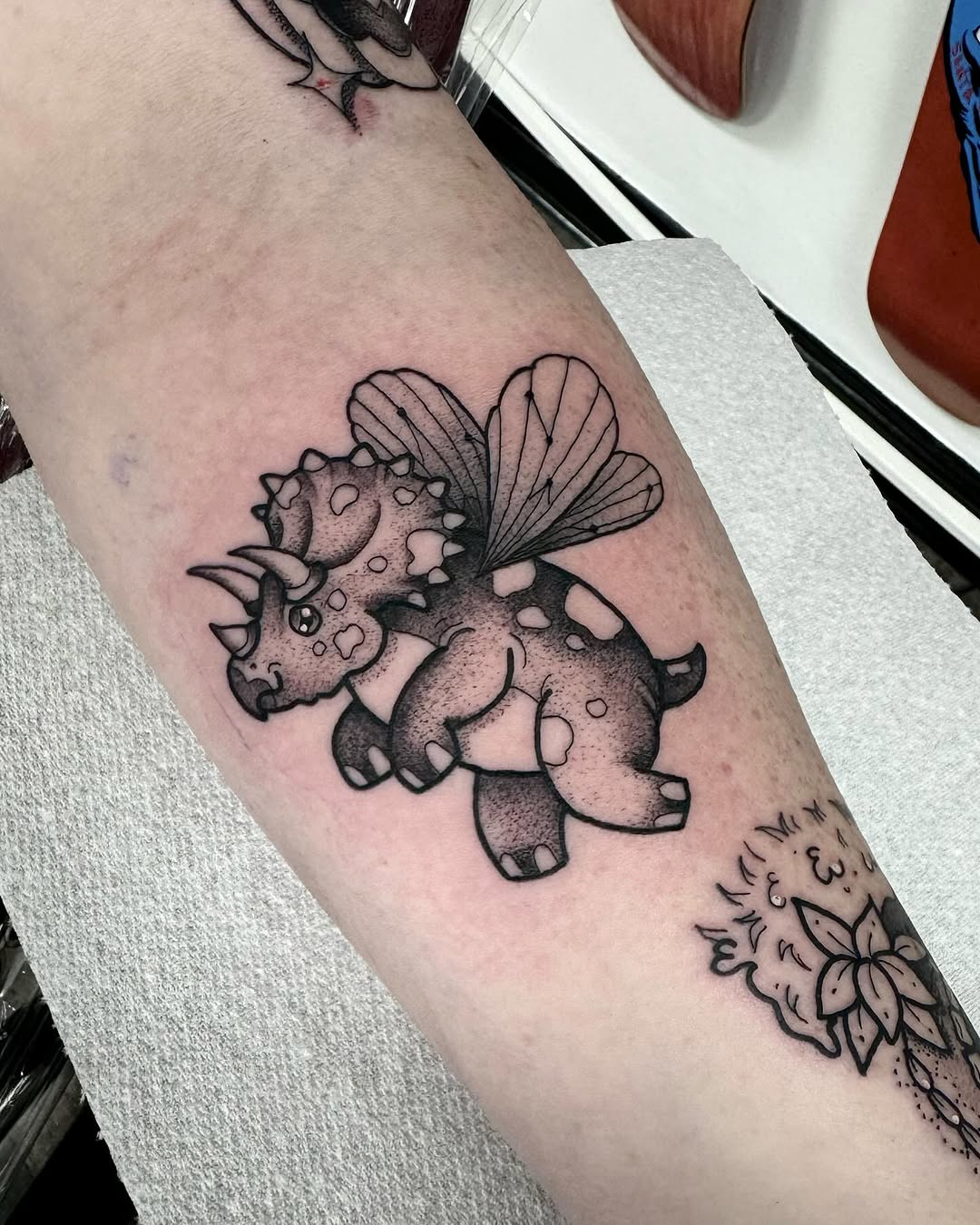 Adorable flying triceratops tattoo design