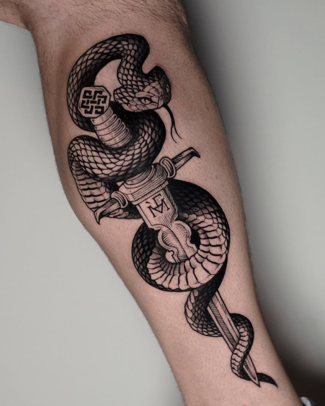 Intricate dagger and snake tattoo design