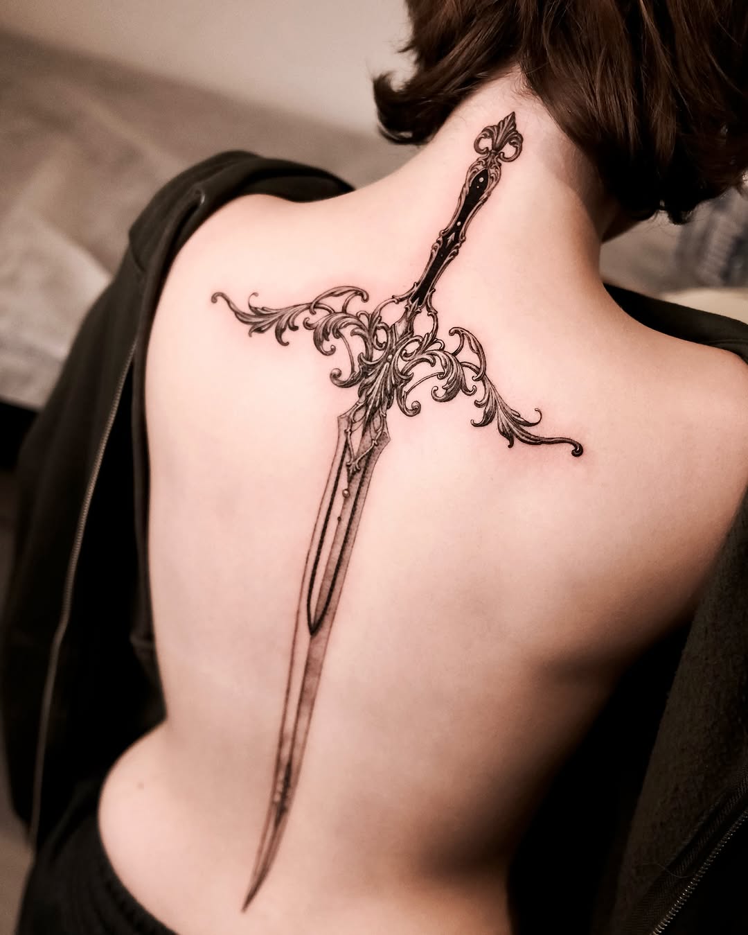 Intricately designed dagger tattoo on back