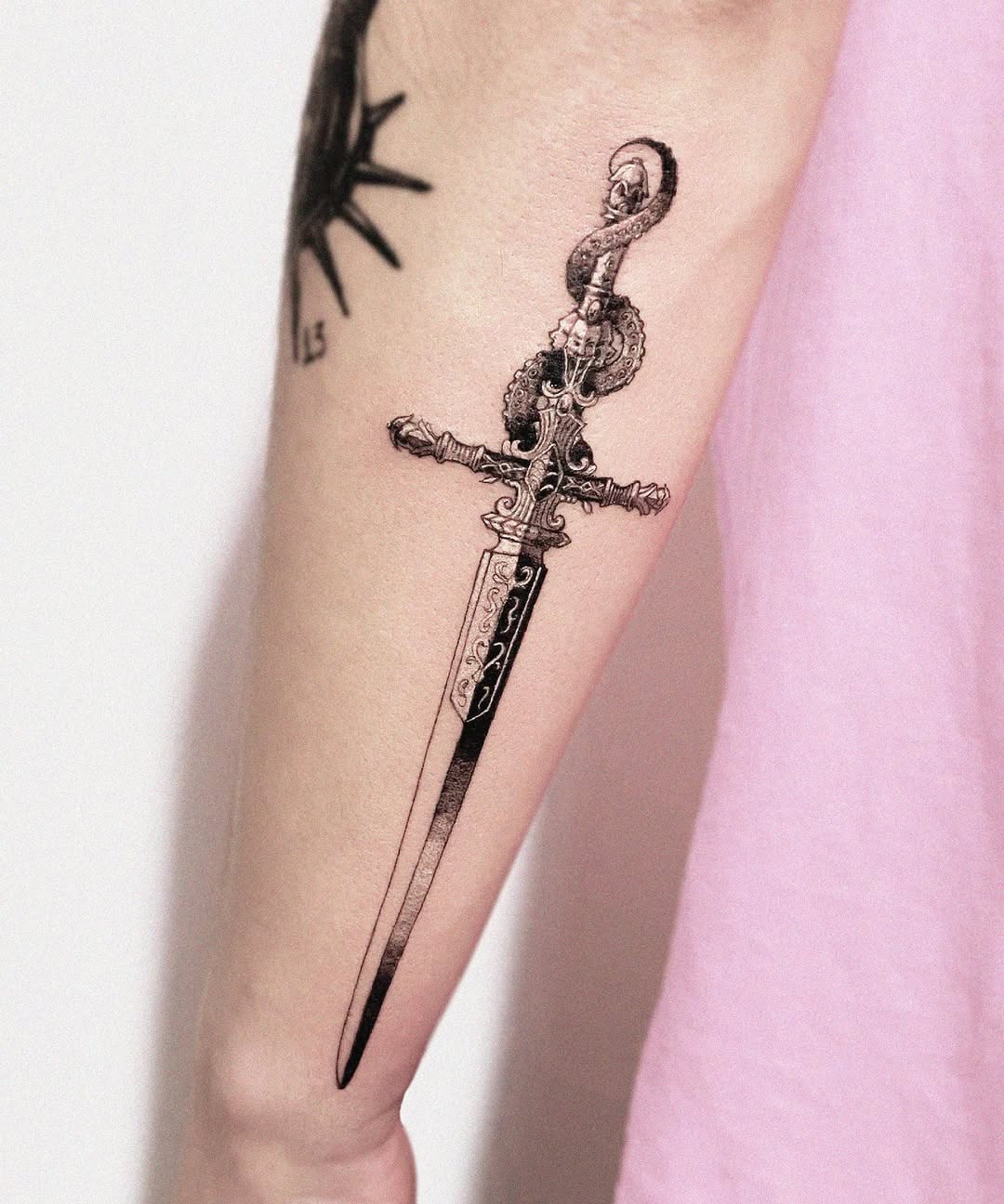 Intricate black ink dagger tattoo design