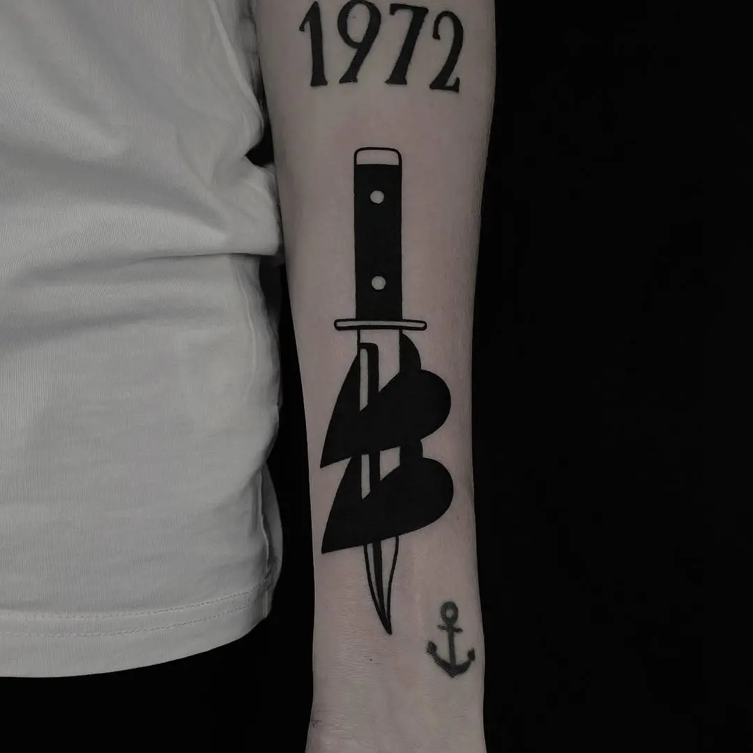 Bold dagger tattoo with heart design
