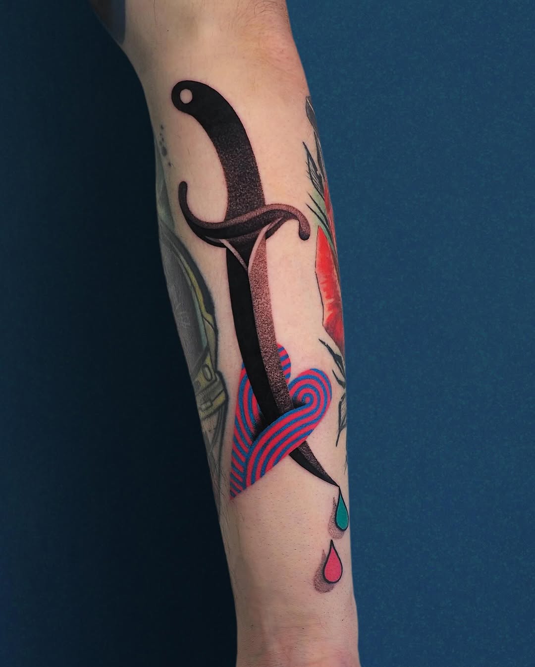 Vibrant dagger tattoo with heart and drops
