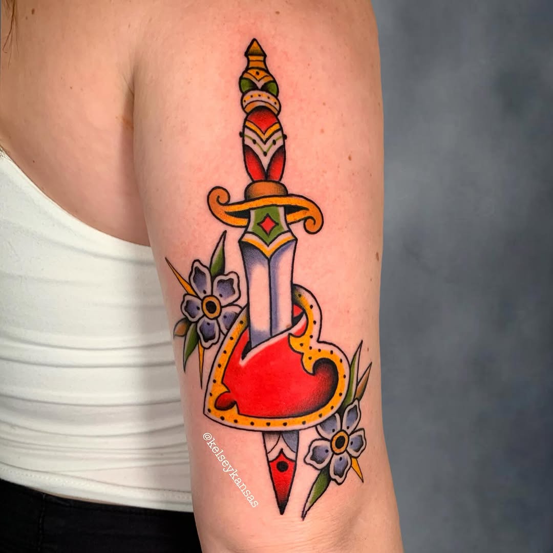 Vibrant dagger tattoo with floral accents