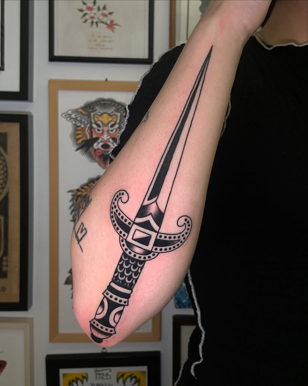 Bold dagger tattoo with artistic flair