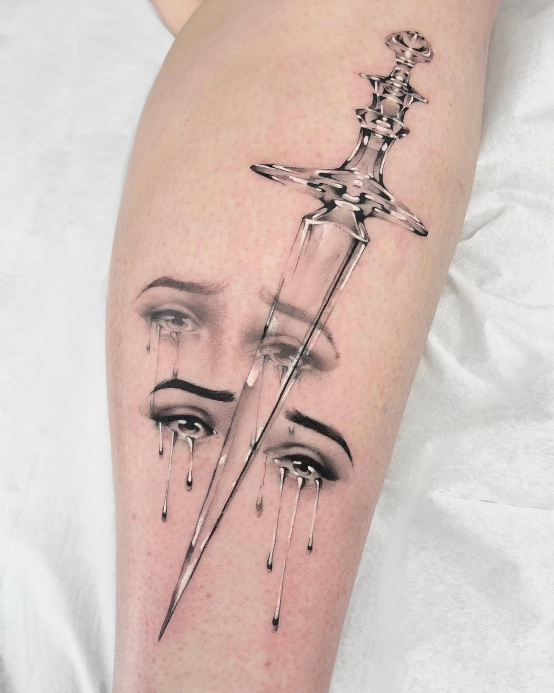 Melancholic dagger tattoo with cascading tears