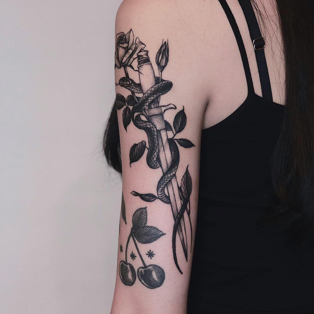 Intricate dagger tattoo with floral elements