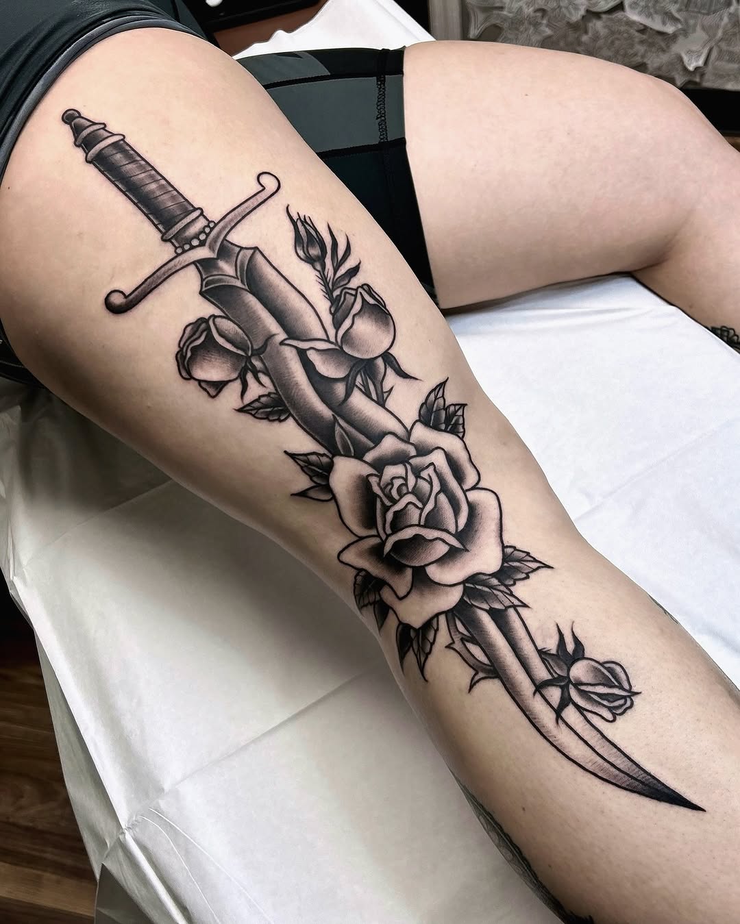 Stunning dagger tattoo adorned with roses