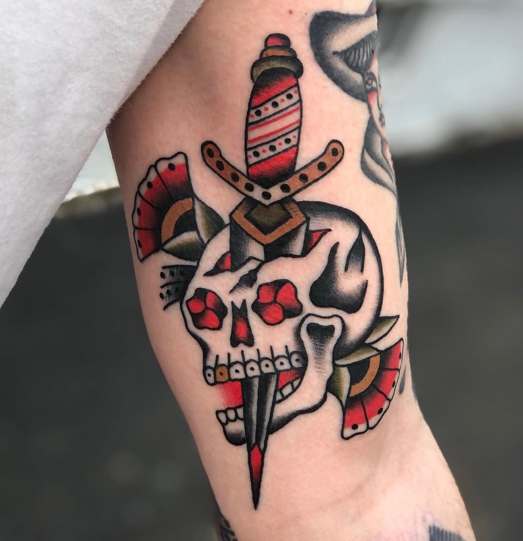 Striking dagger and skull tattoo art