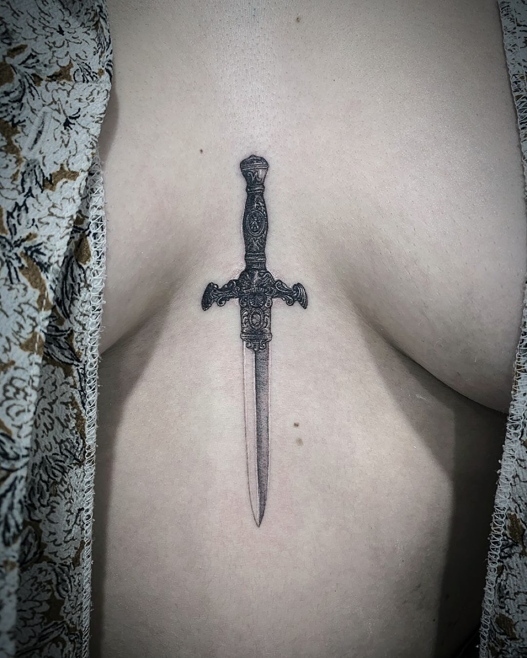 Elegant dagger tattoo showcasing intricate detailing