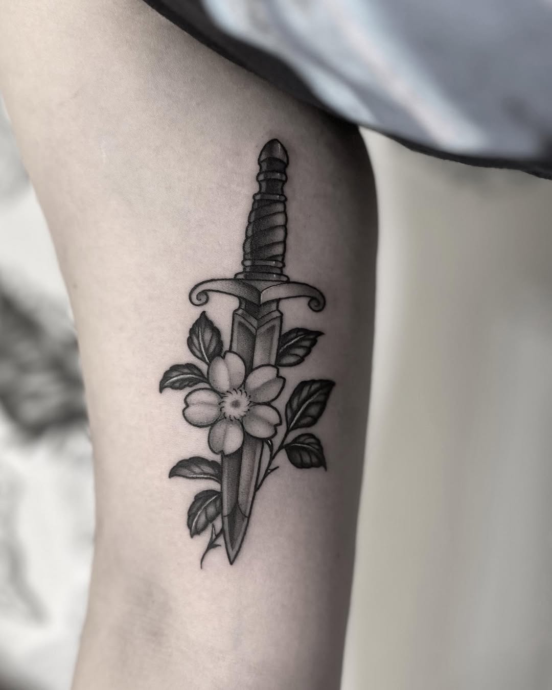 Stylish dagger tattoo with floral accents