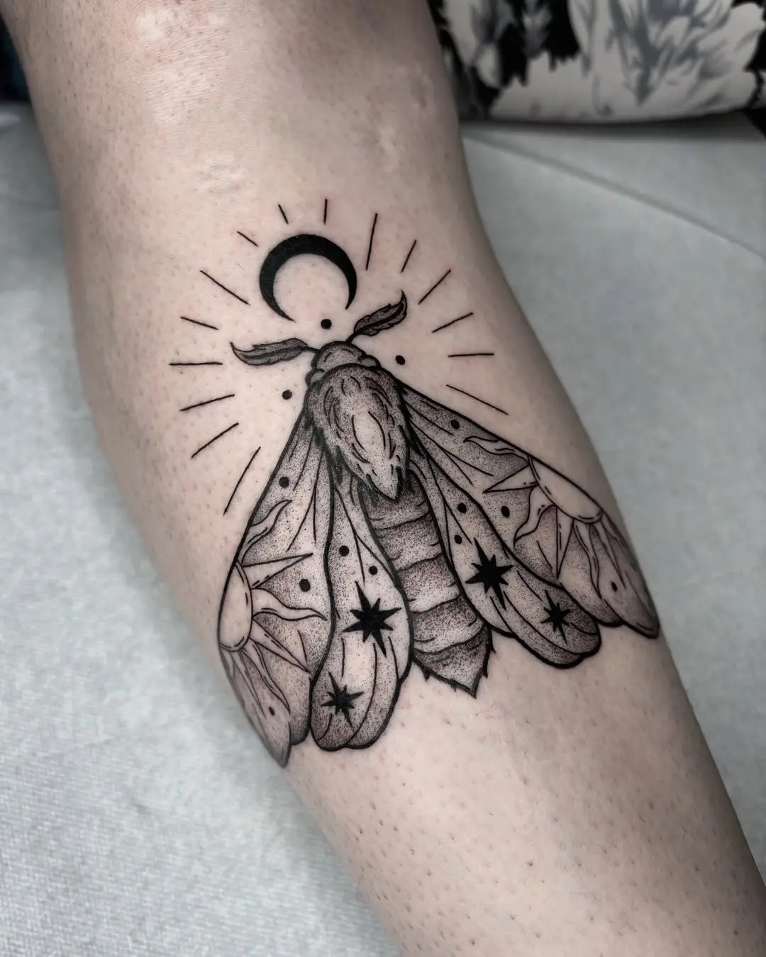 Elegant moth tattoo with celestial elements