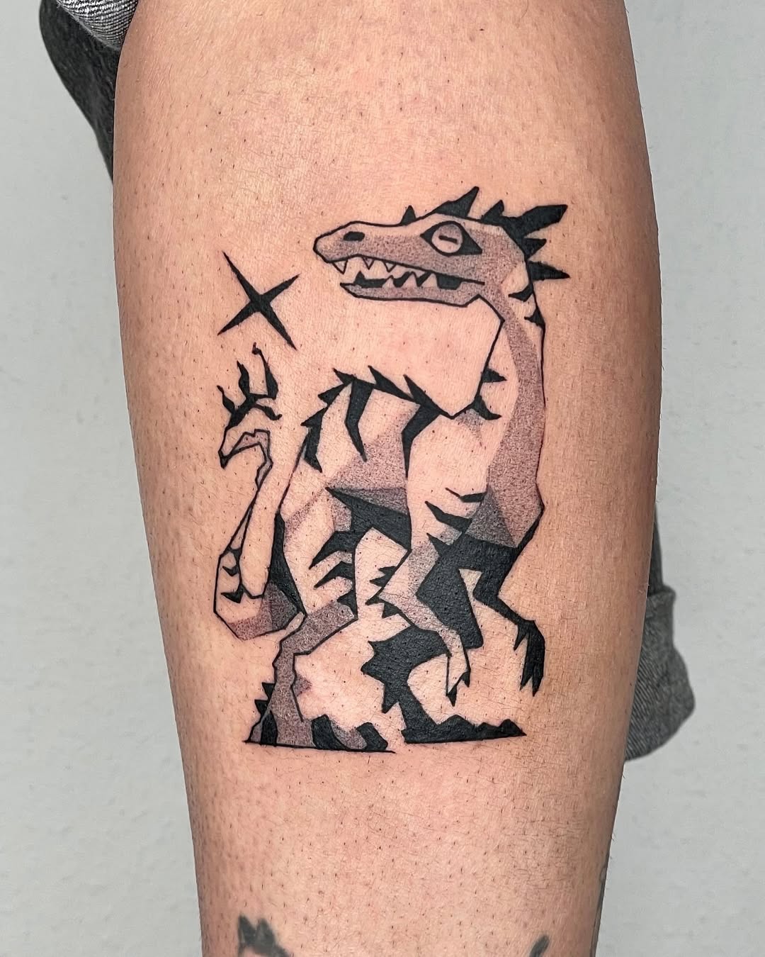 Stylized dinosaur tattoo with sharp lines