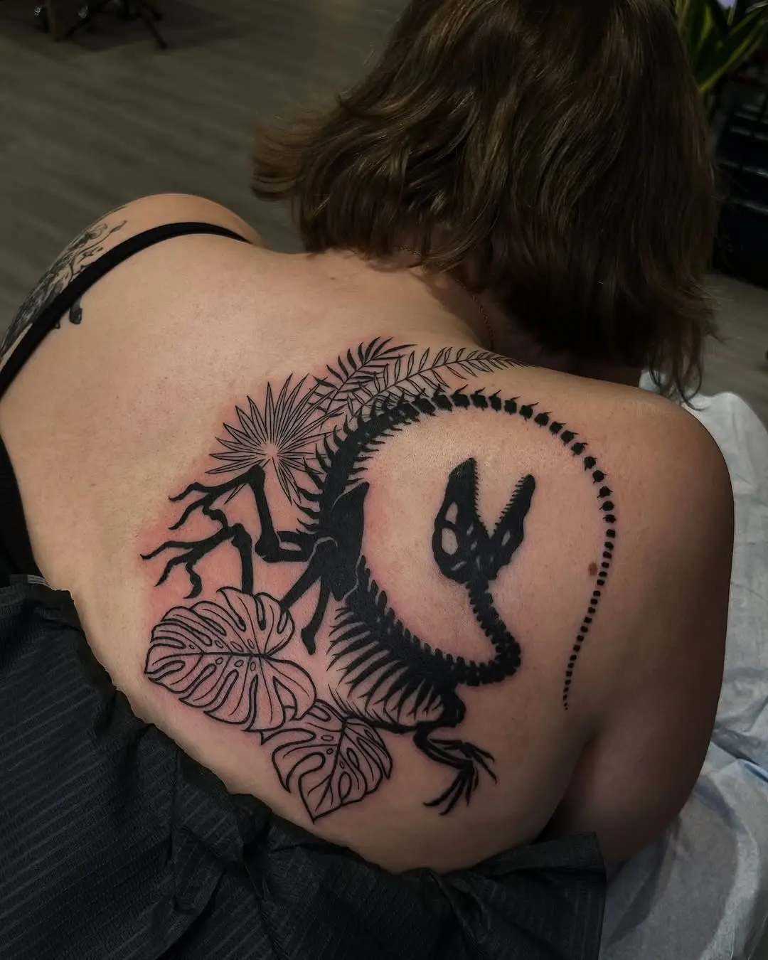 Stylish dinosaur tattoo with tropical vibes