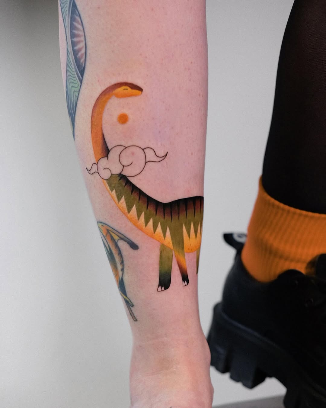 Vibrant Brachiosaurus Tattoo with Cloud Elements