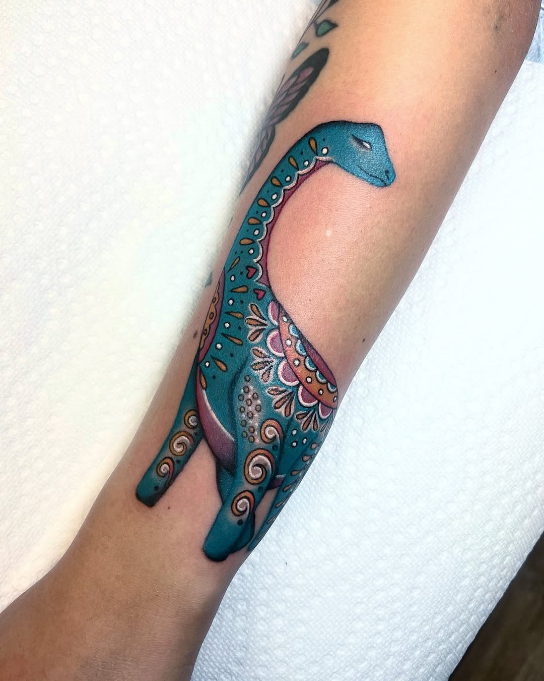 Colorful dinosaur tattoo with unique artistic flair