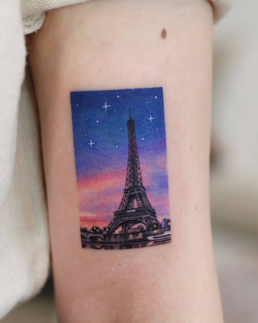 Stunning Eiffel Tower tattoo with pastel sunset hues