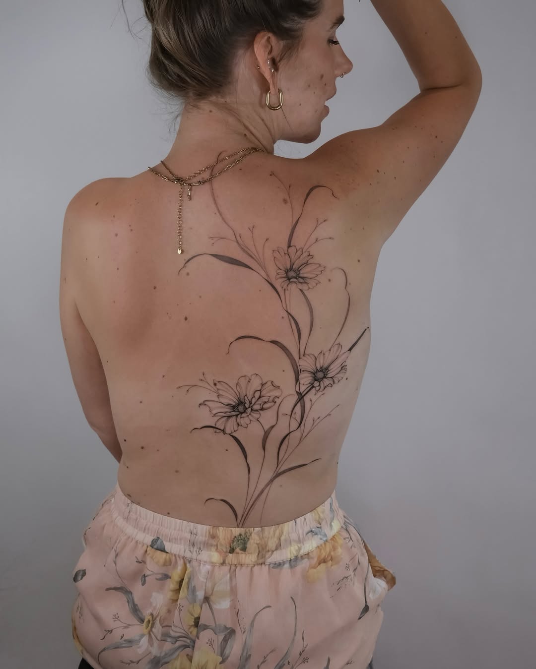 Delicate floral back tattoo design for women