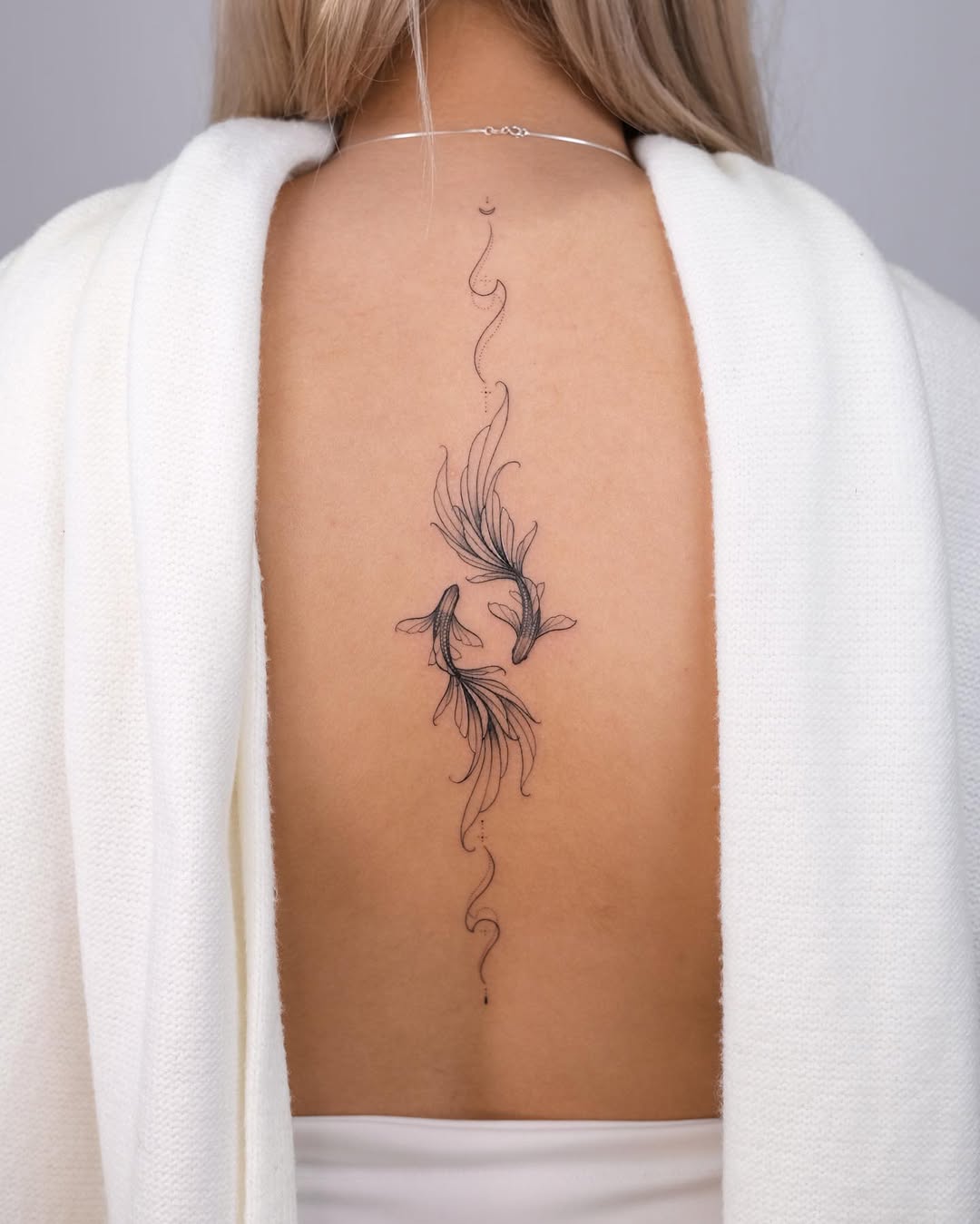 Elegant linear Pisces tattoo on the back