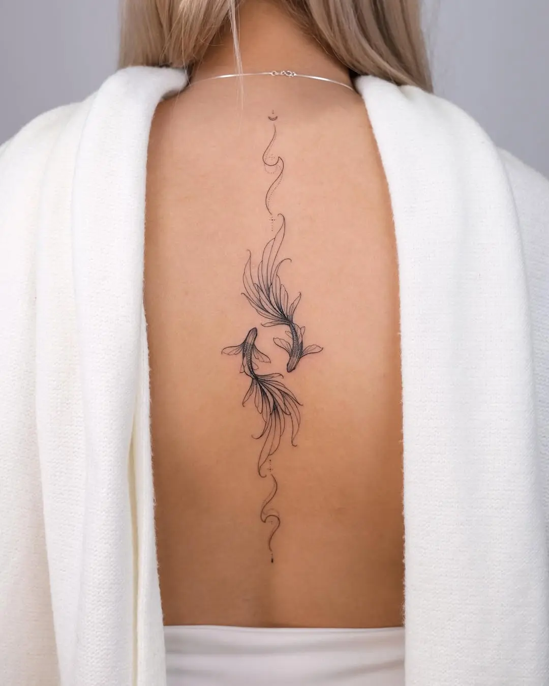Elegant linear Pisces tattoo on the back