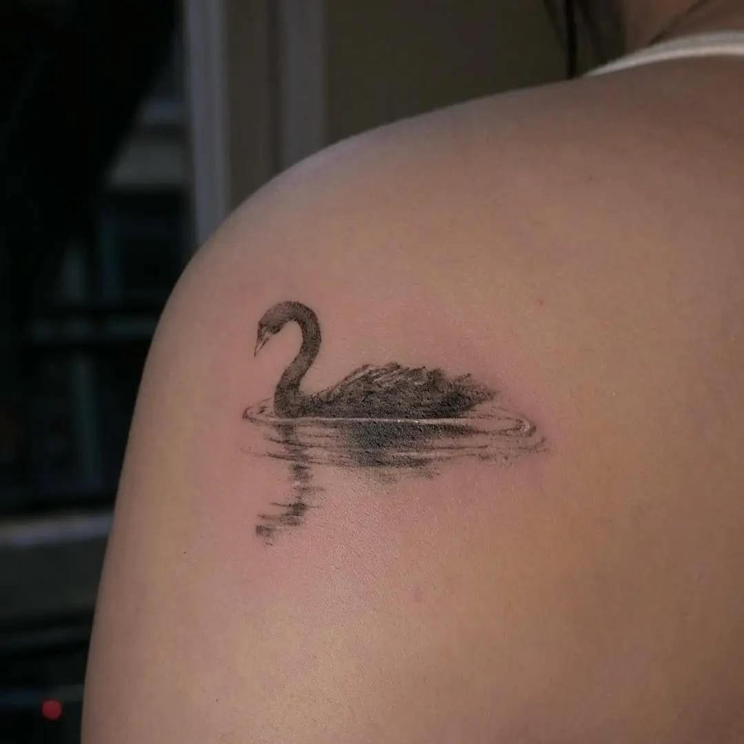 Elegant swan tattoo with serene water reflections