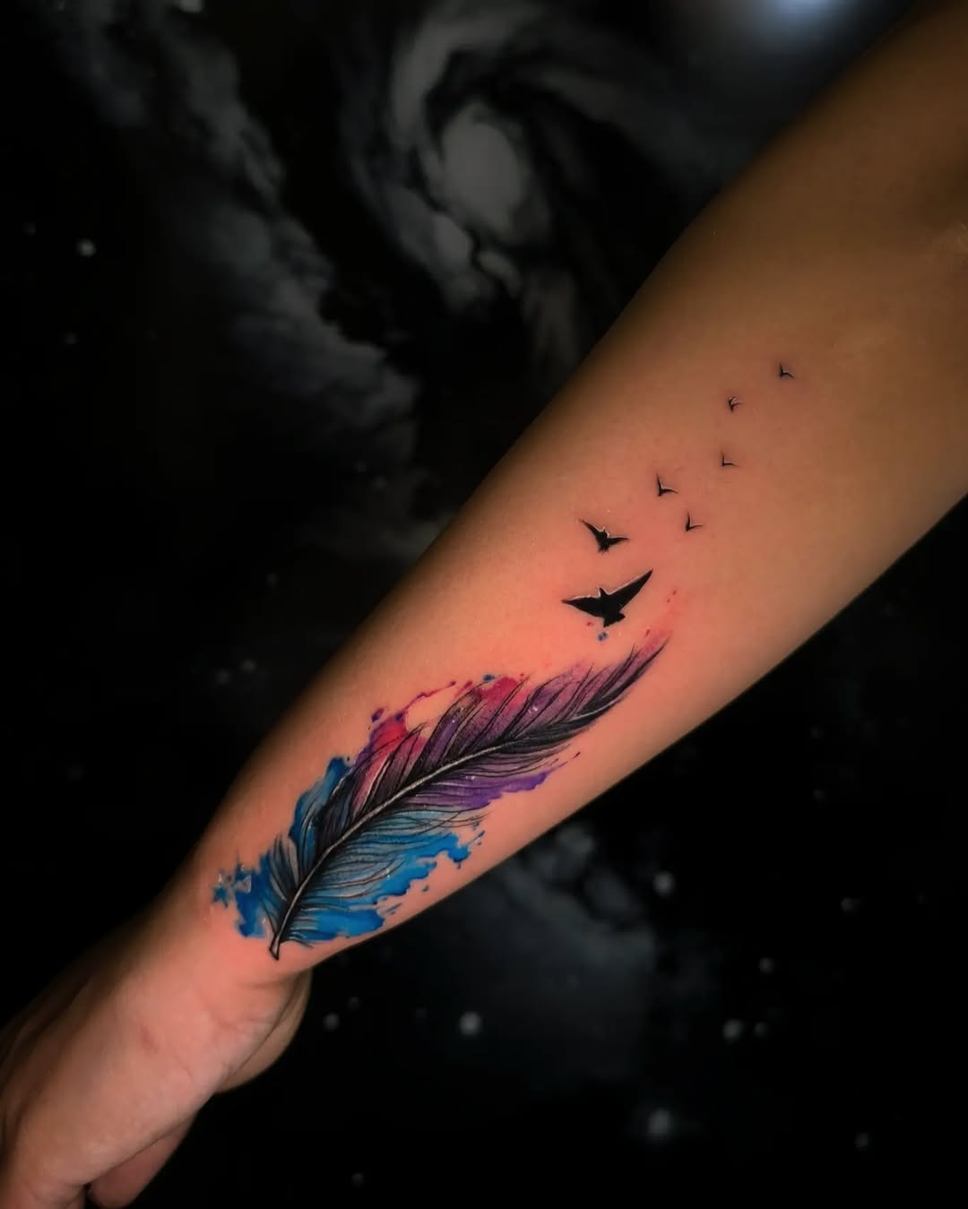 Vibrant feather tattoo with flying birds