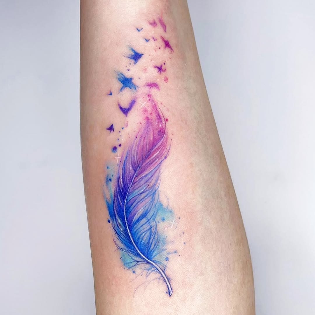 Vibrant feather tattoo with flowing watercolor design